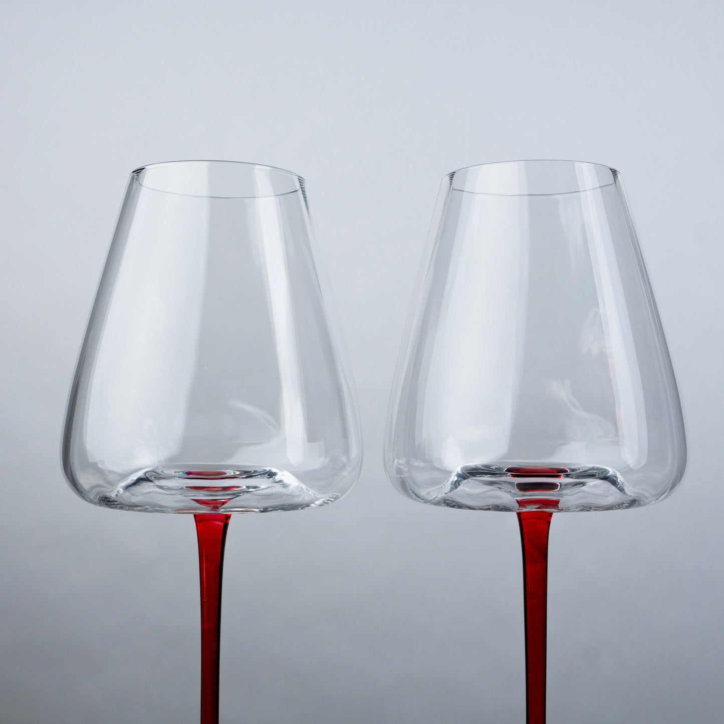 set of 4 clear wine glasses with slim red stem and black base