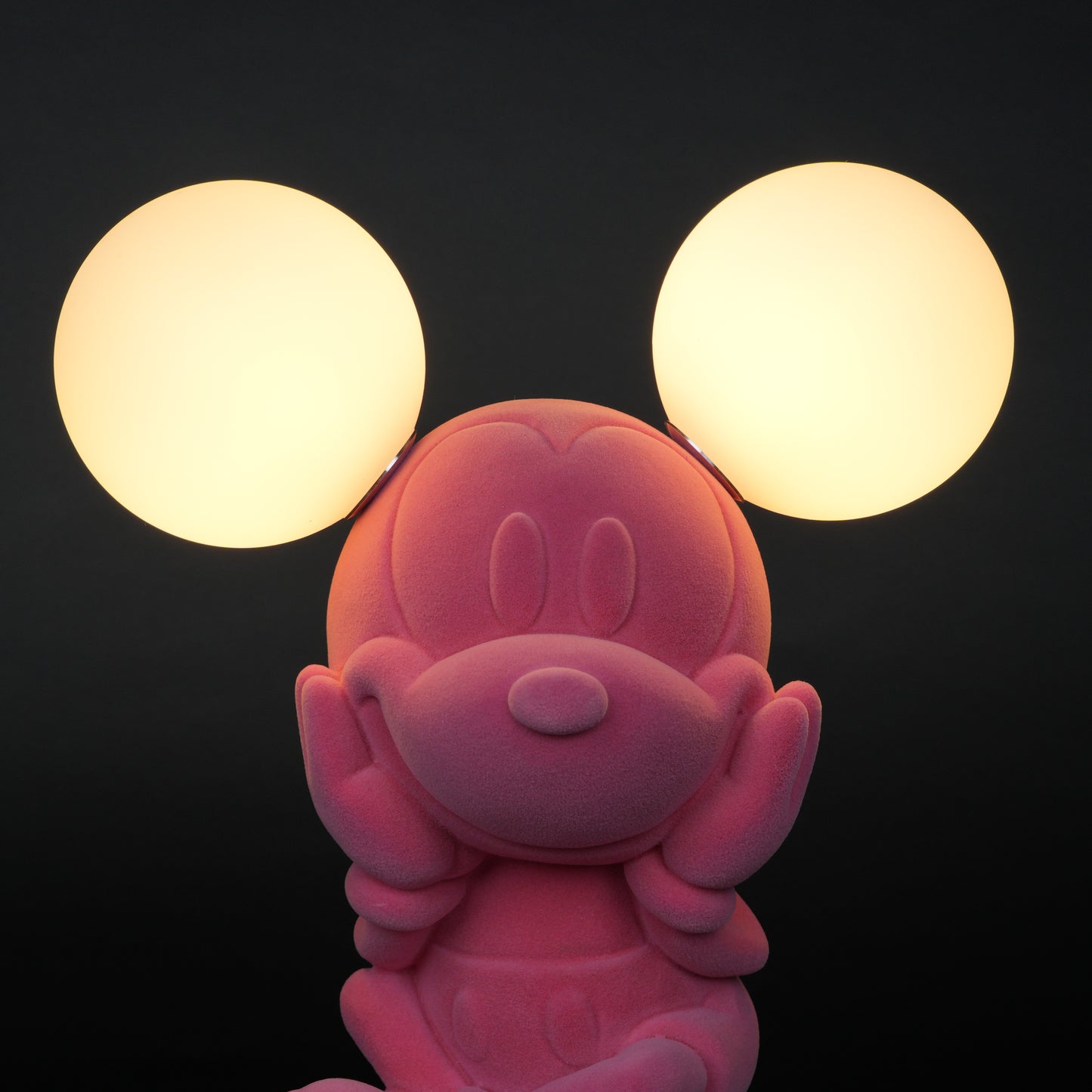 Pink figurine lamp with two warm glowing orb lights on top.