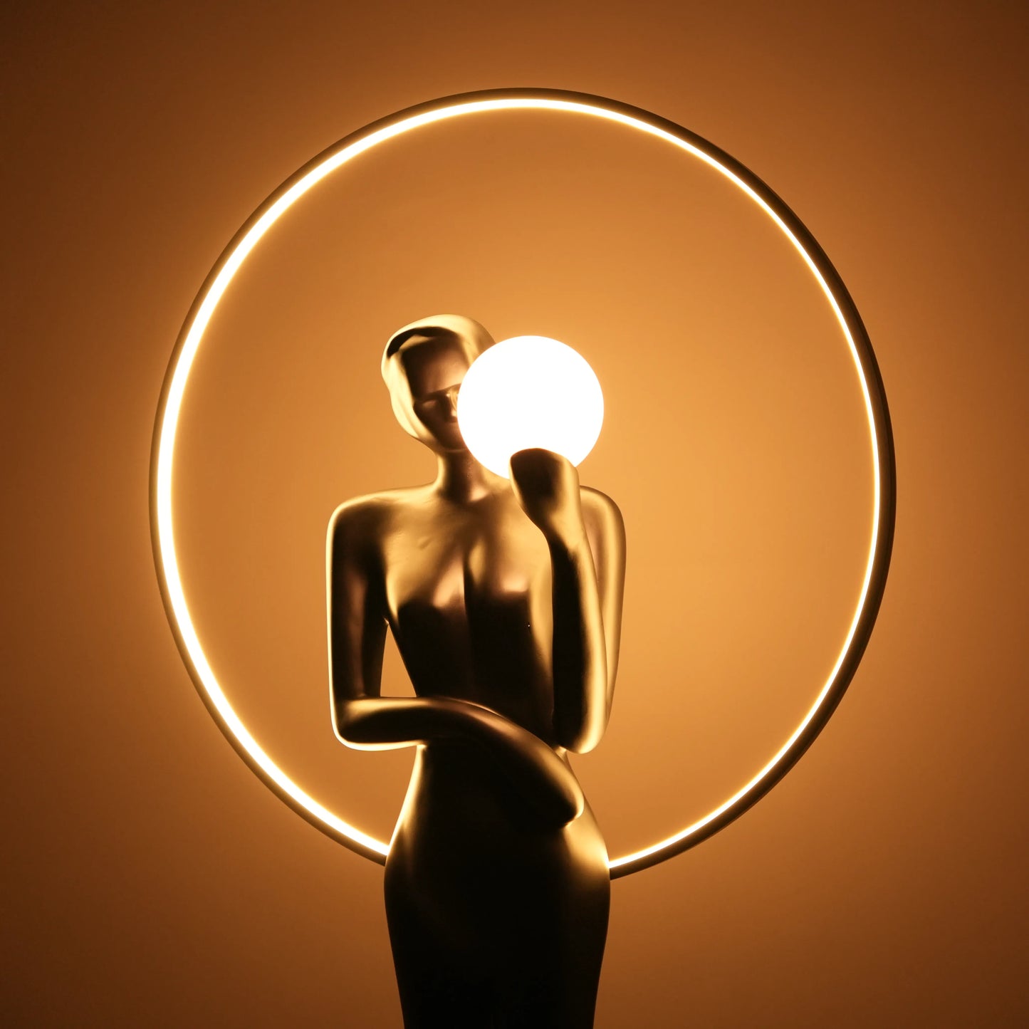 Tall matte-black lady sculpture floor lamp with glowing halo ring and warm globe light