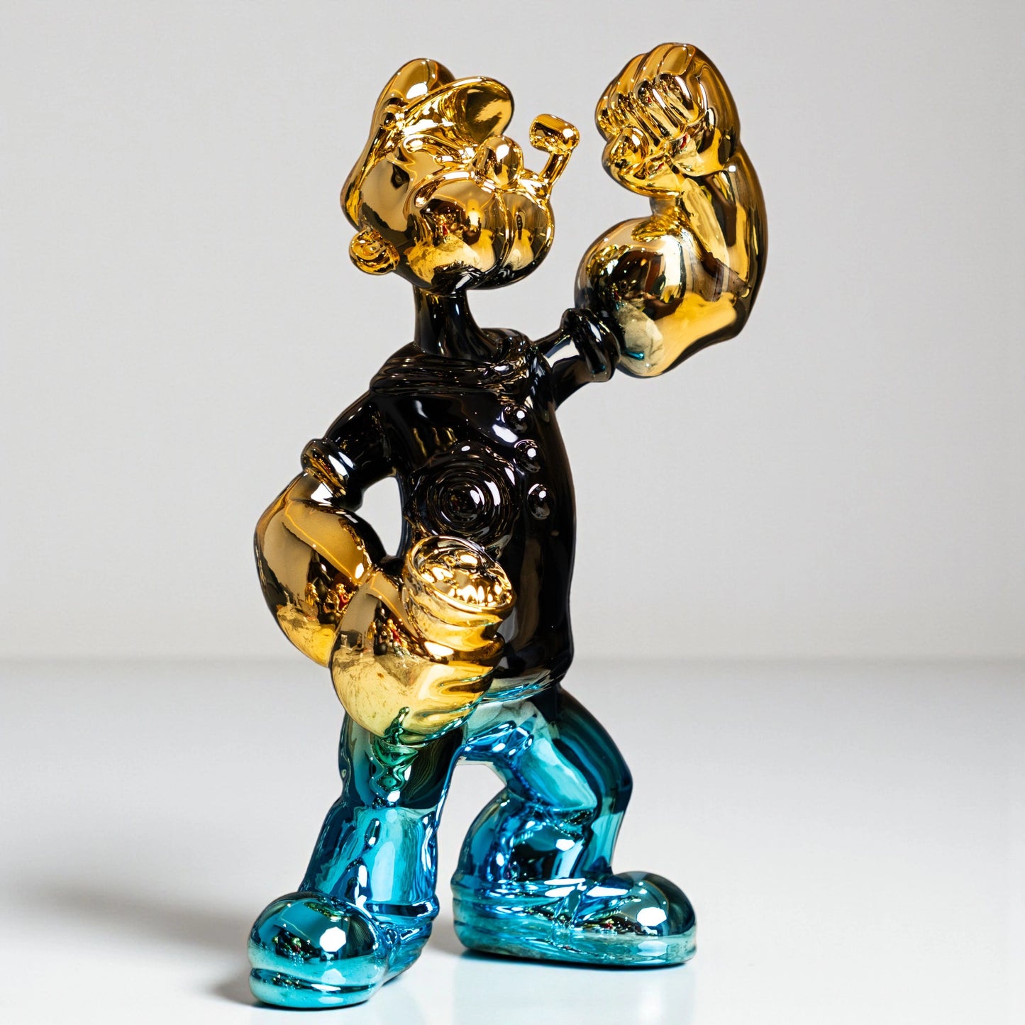 Aqua and gold metallic resin figurine in a dynamic pose — luxury high-gloss decorative sculpture by Ghar Art.