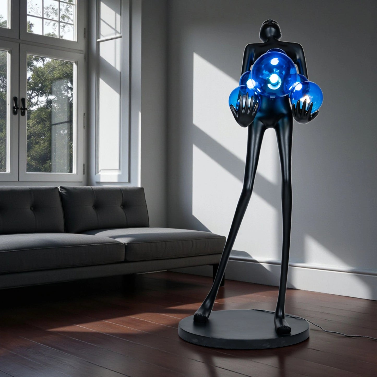 Tall matte black sculpture of human figure holding glowing blue light spheres — Azure Radiance Sculpture by Ghar Art, handcrafted illuminated modern home decor accent.