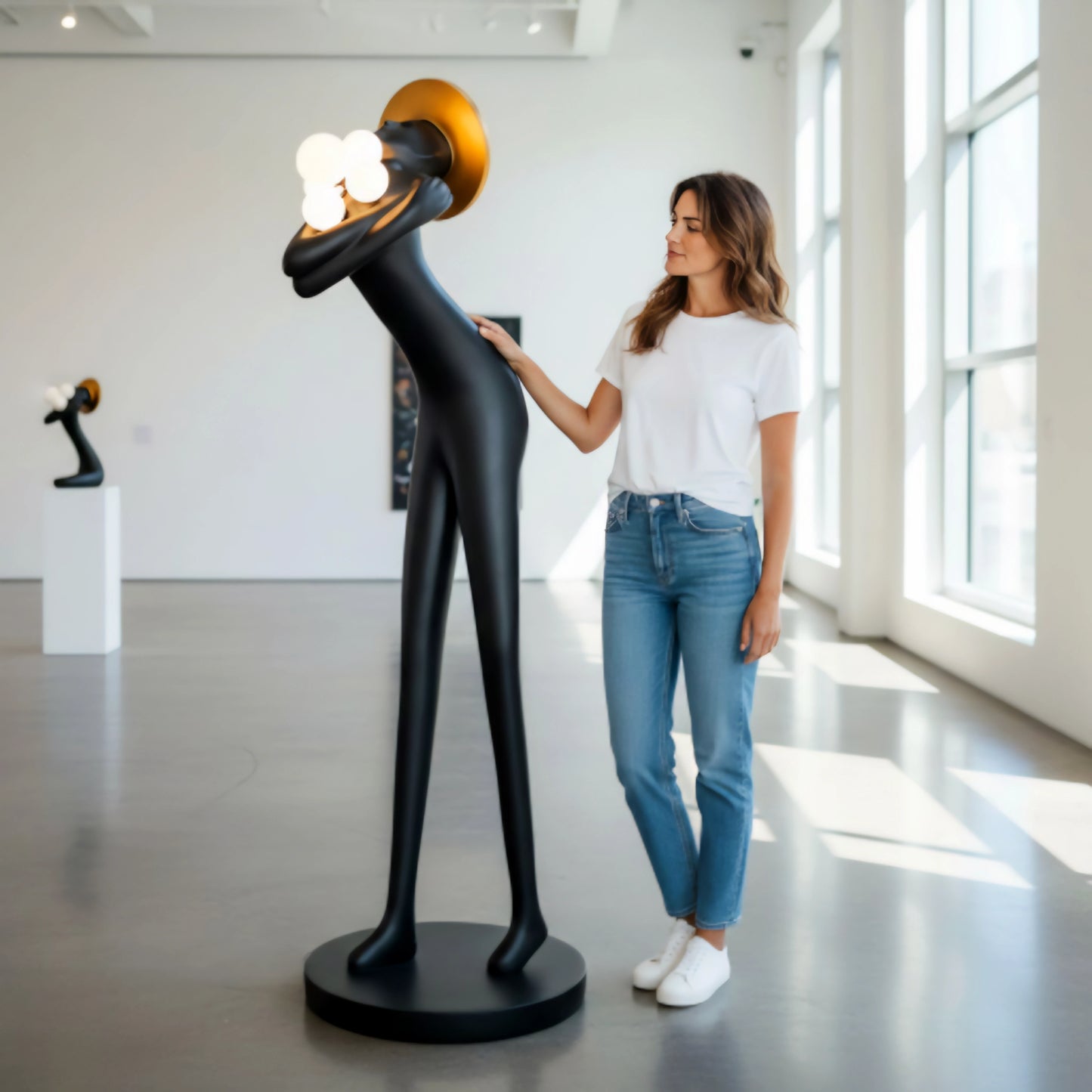 Tall black human-form floor sculpture holding glowing light orbs