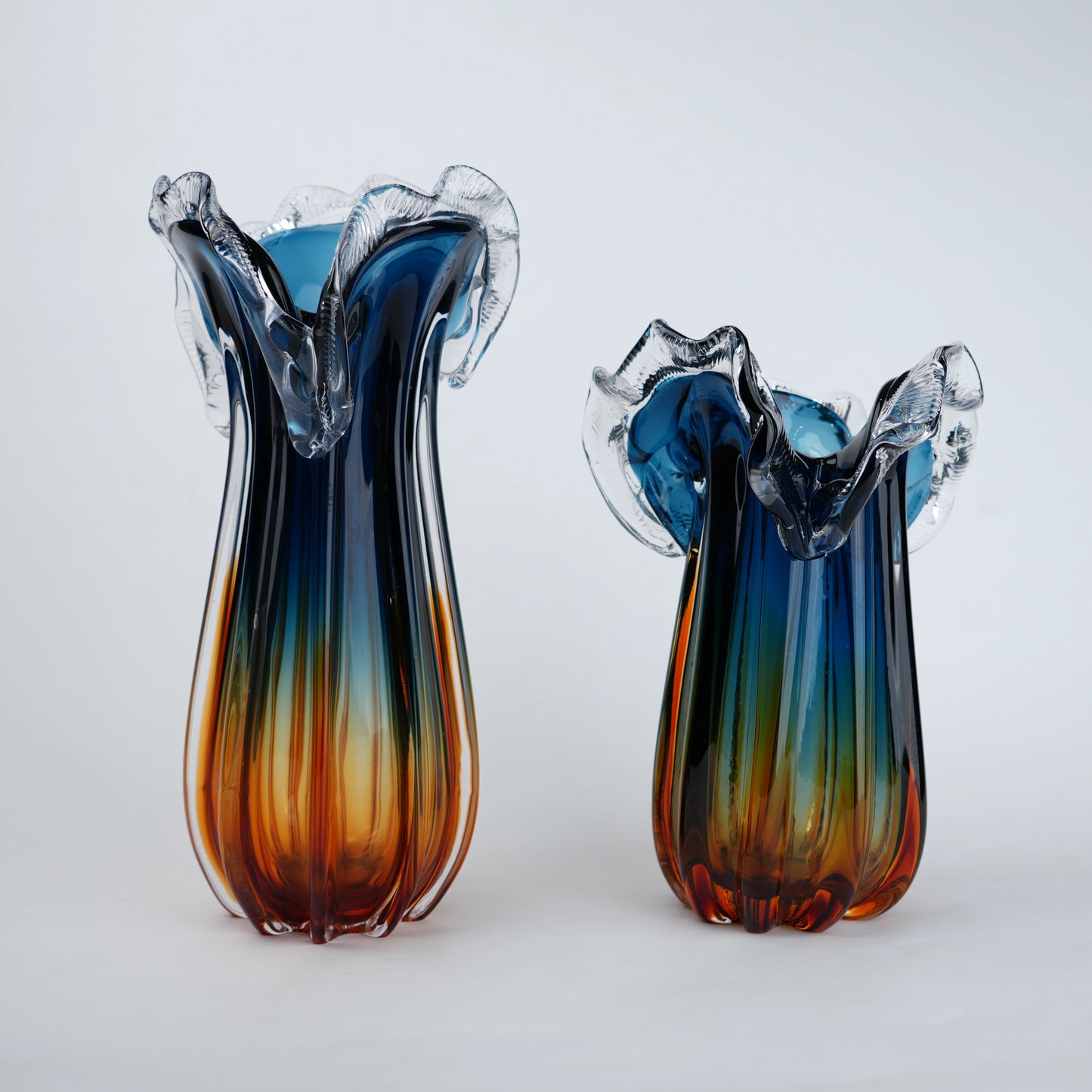 Two glass vases with blue and orange gradient on a white background