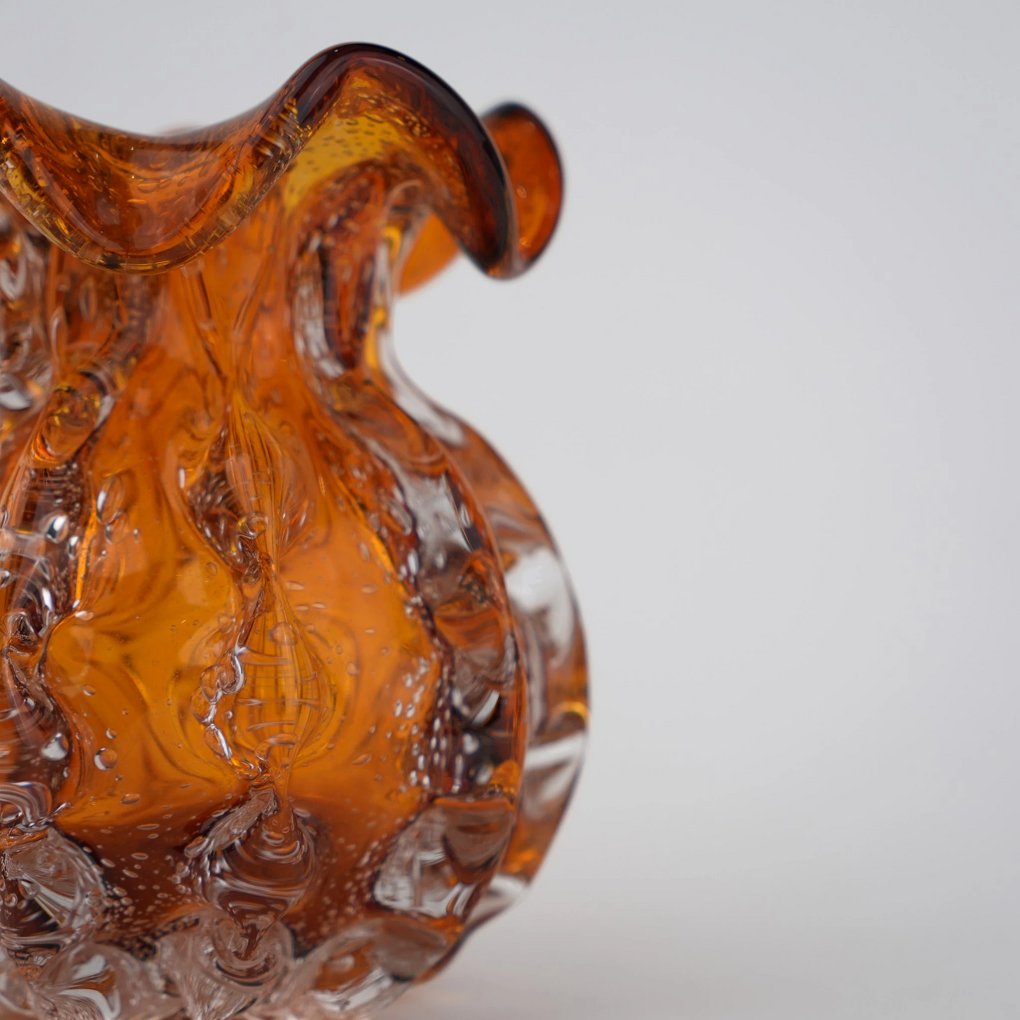 Sculptural amber-toned art glass vase with textured molten-inspired silhouette.
