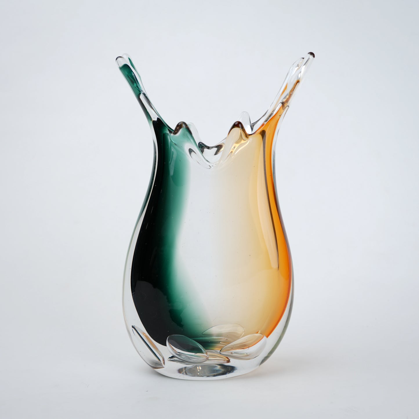 Glass vase with a gradient from green to orange on a white background