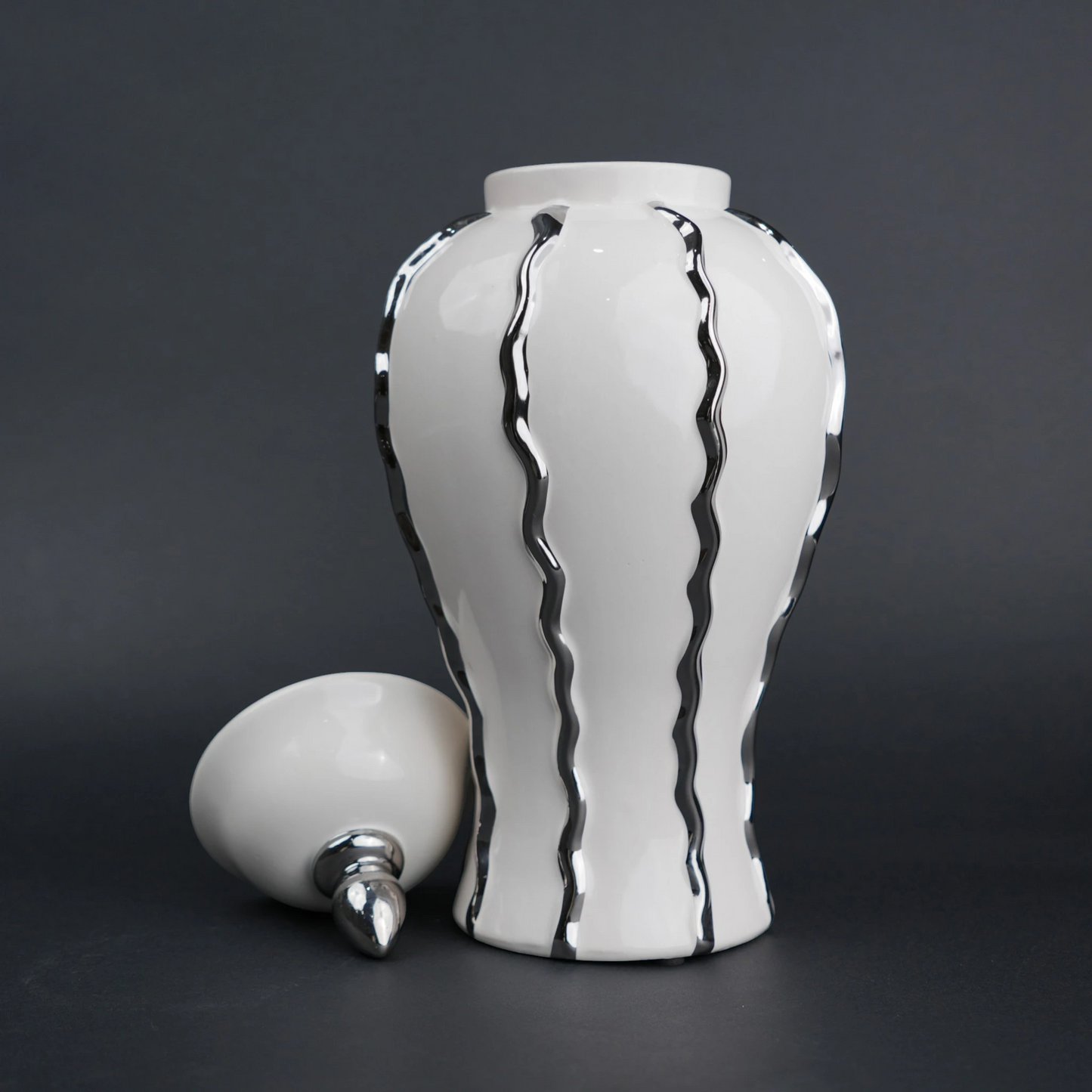 Ivory ceramic decorative jar with flowing metallic accents and lid