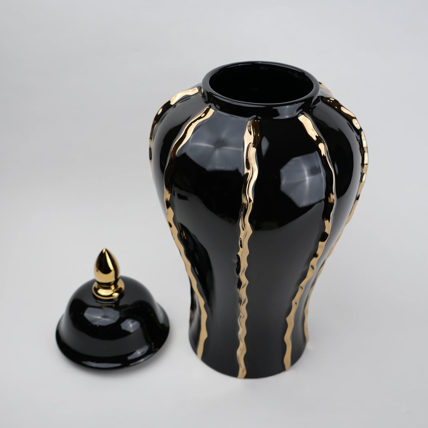 Black ceramic decorative jar with gold flowing accents and lid