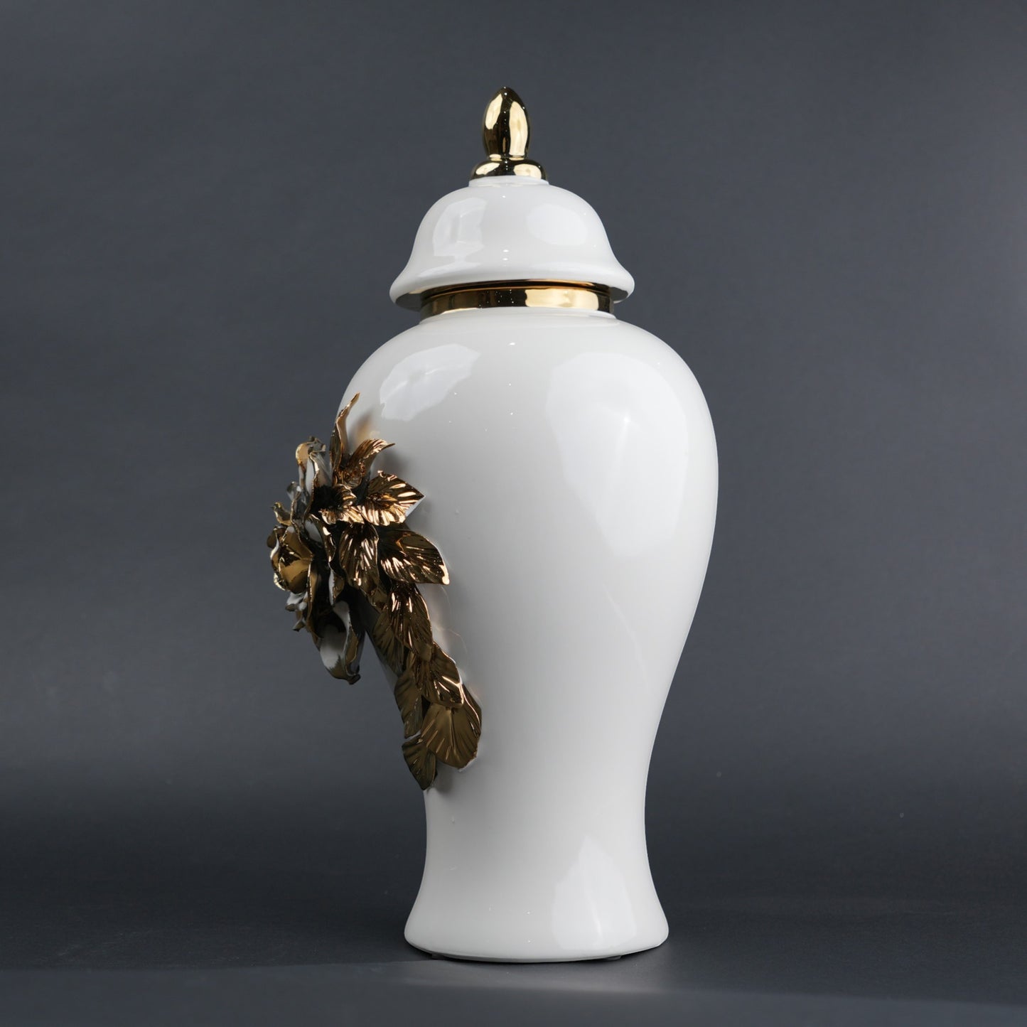 White ceramic jar with gold leaf design and lid on a