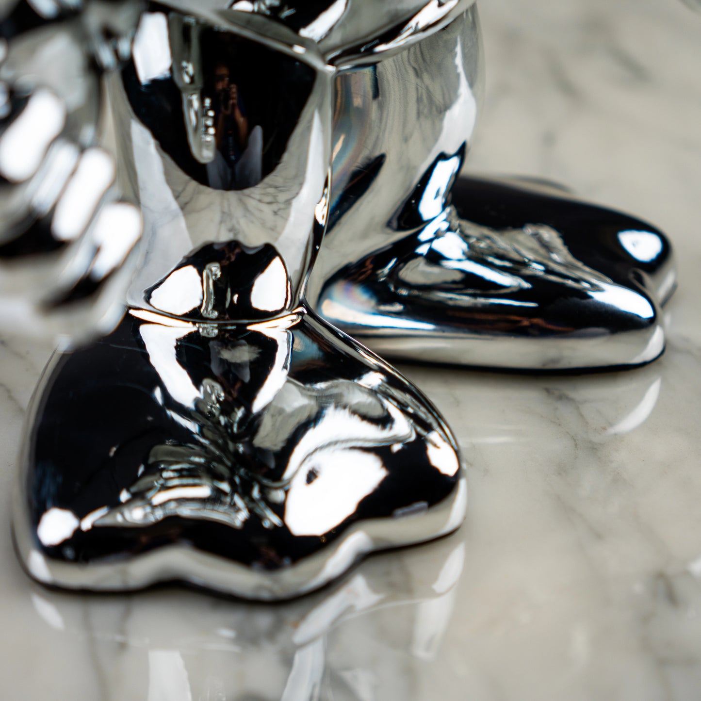 Chrome duck glossy boots macro on marble