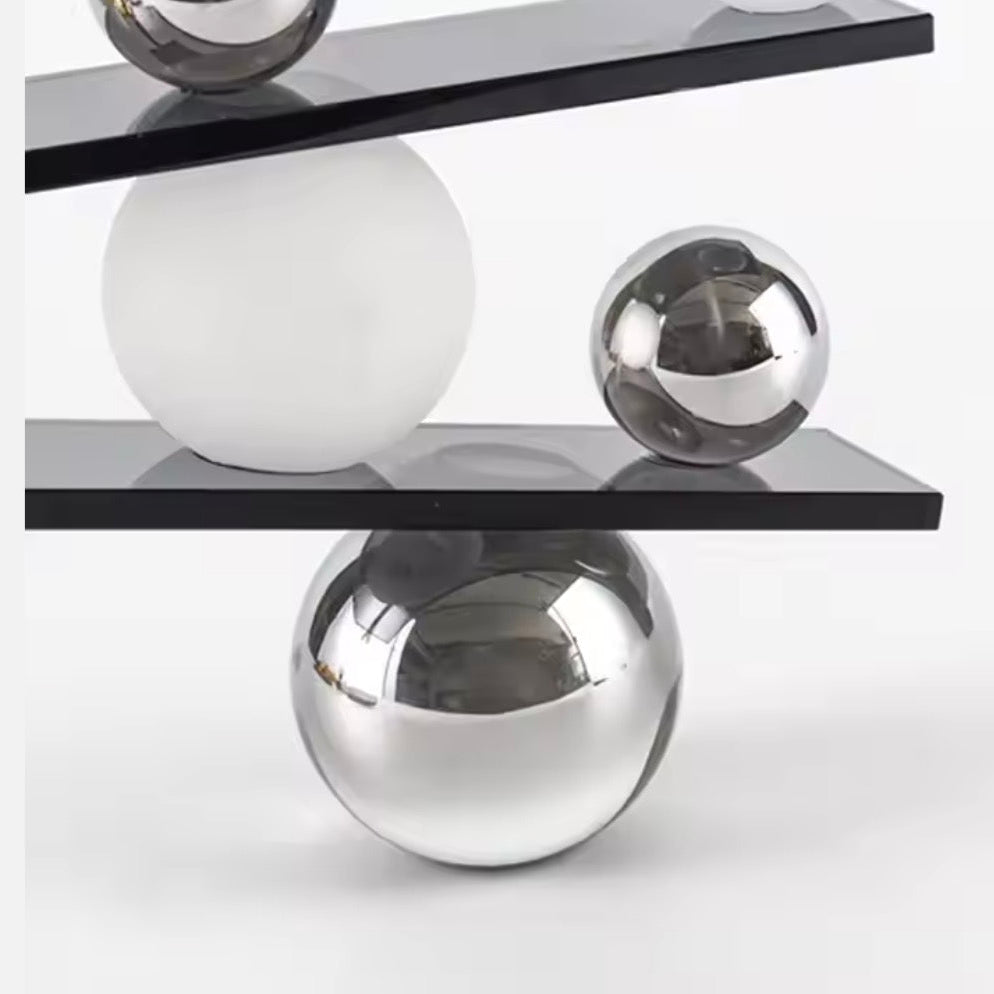 Abstract balancing sculpture with chrome spheres and a small gold figurine