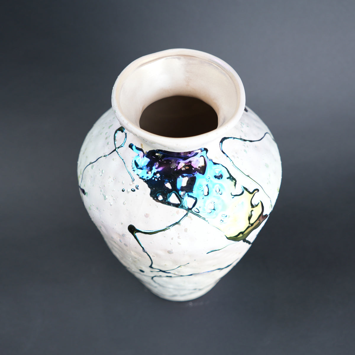 Ceramic vase with abstract designs on a dark background
