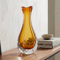 Amber clear art glass decorative vase with layered color center and elongated glass form.
