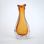 Amber clear art glass decorative vase with layered color center and elongated glass form.