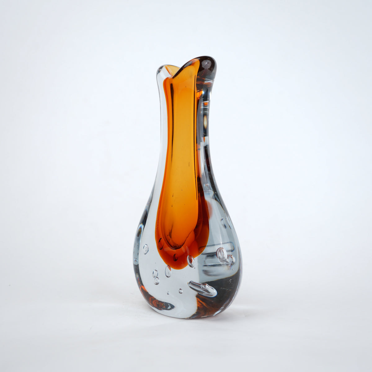 Amber clear art glass decorative vase with layered color center and elongated glass form.
