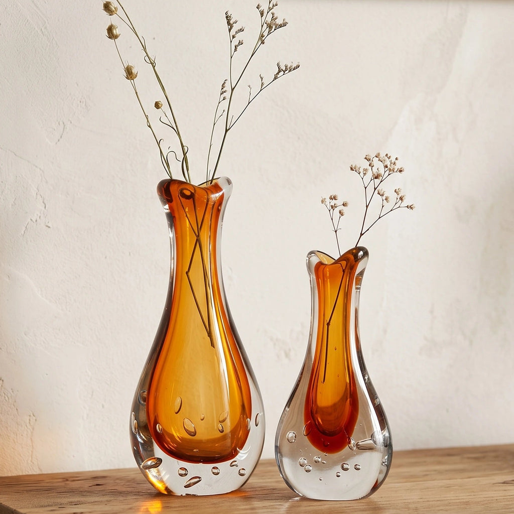 Amber clear art glass decorative vase with layered color center and elongated glass form.