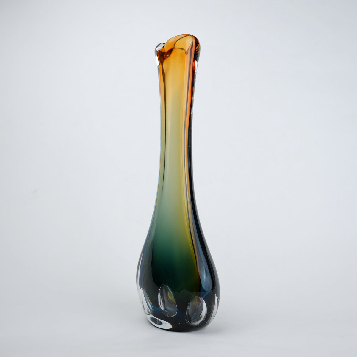 Glass vase with gradient color from brown to green on a white background