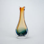 Glass vase with gradient color from orange to blue on a light gray background