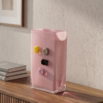 Pink art glass vase with embedded multicolor accents and wide rectangular form.