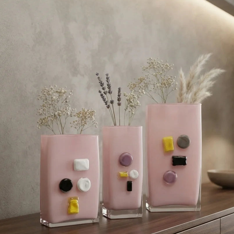Pink art glass vase with embedded multicolor accents and wide rectangular form.