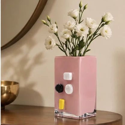 Pink art glass vase with embedded multicolor accents and wide rectangular form.