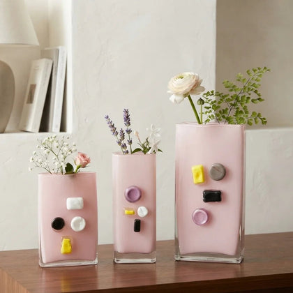 Pink art glass vase with embedded multicolor accents and wide rectangular form.