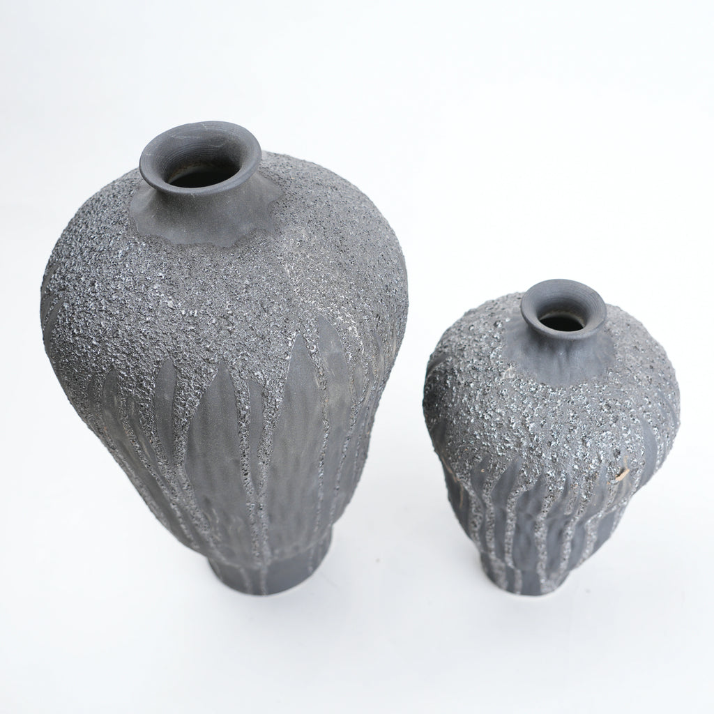 Two gray textured vases on a white background