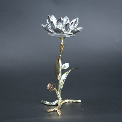 Decorative crystal object on a gold stand against a dark background