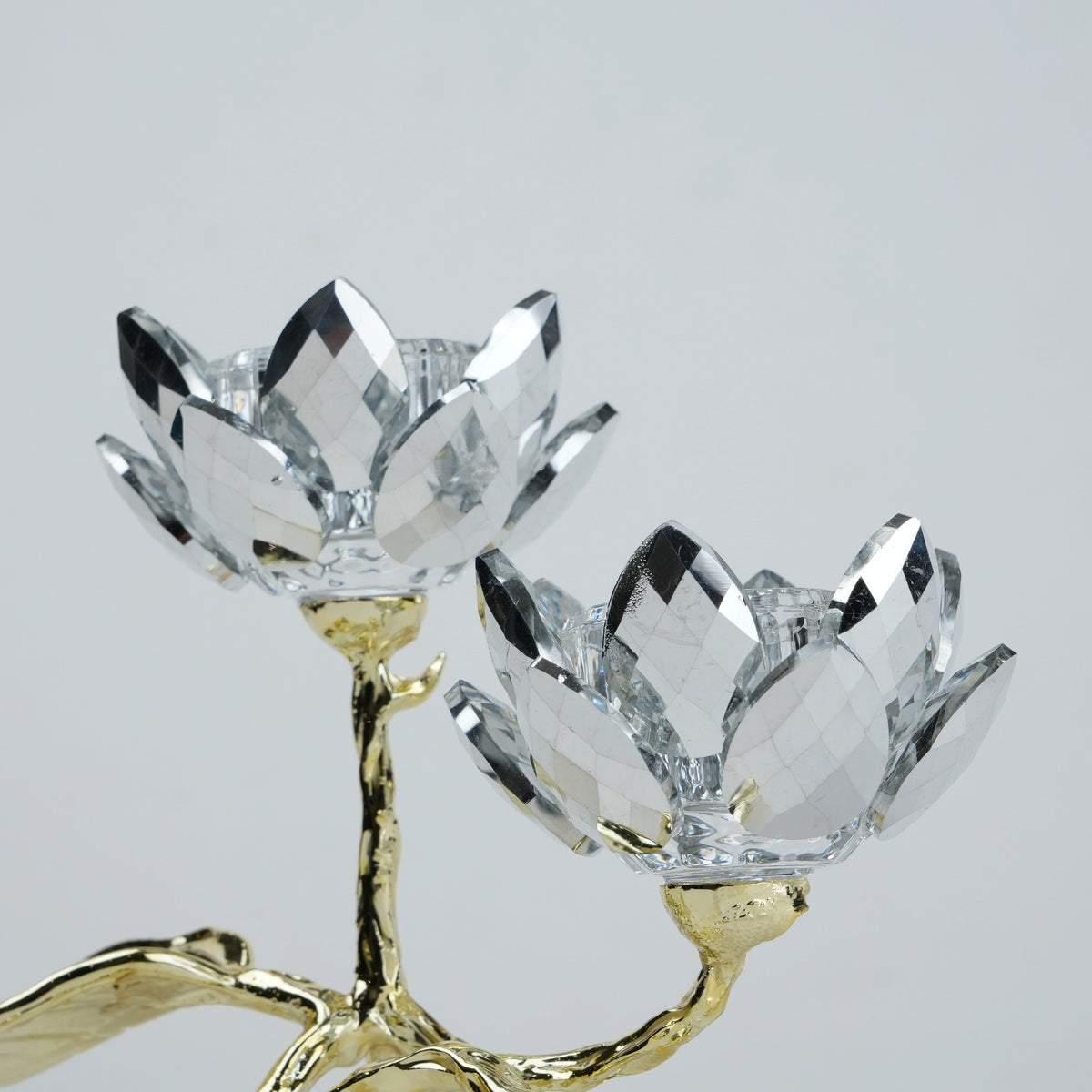 Crystal flower-shaped candle holder with gold base on a light gray background