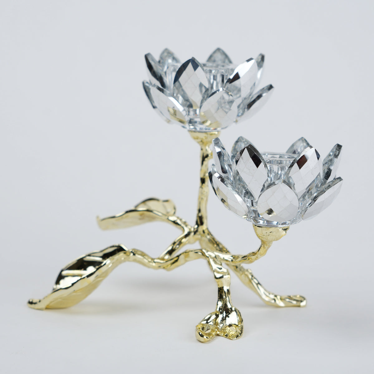 Crystal flower-shaped candle holder with gold base on a light gray background
