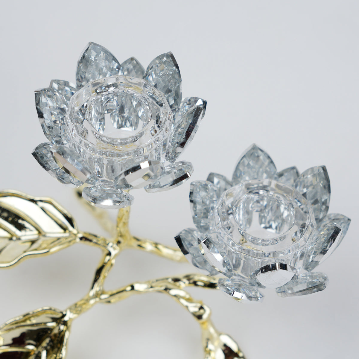 Crystal lotus flowers with gold stem on a light gray background
