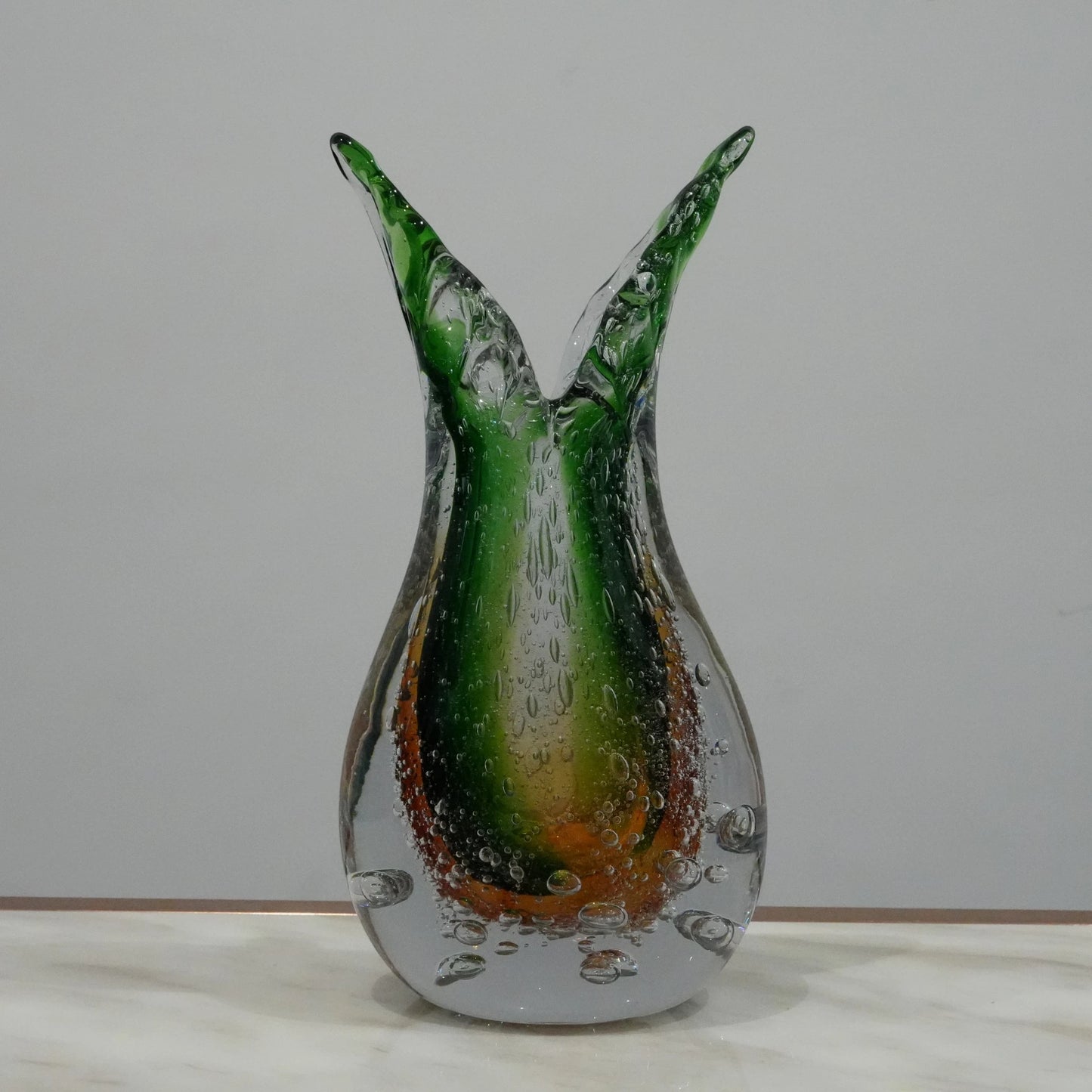 Handblown artistic glass vase with organic twisted silhouette, bubble detailing and green amber gradient finish for luxury decor