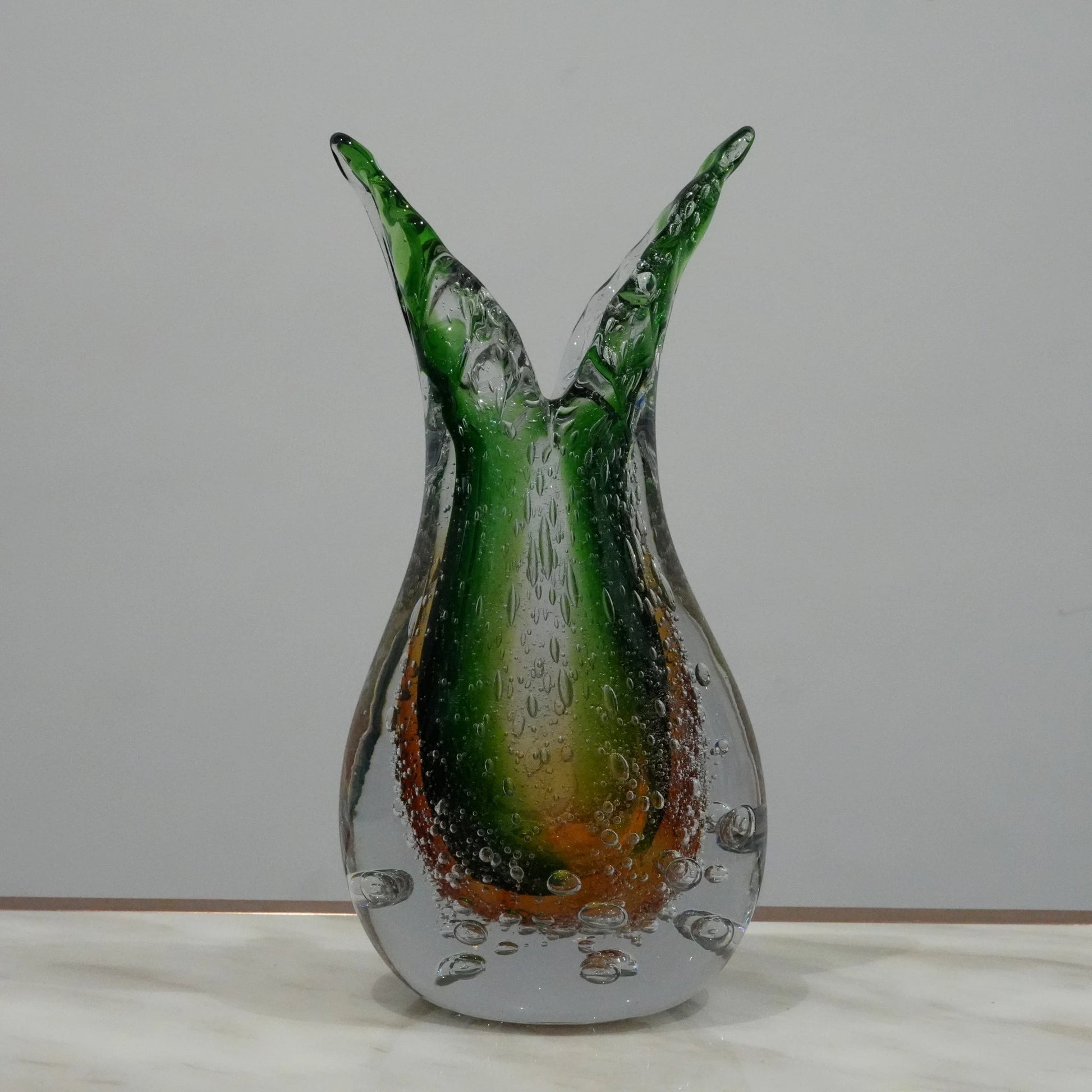 Handblown artistic glass vase with organic twisted silhouette, bubble detailing and green amber gradient finish for luxury decor