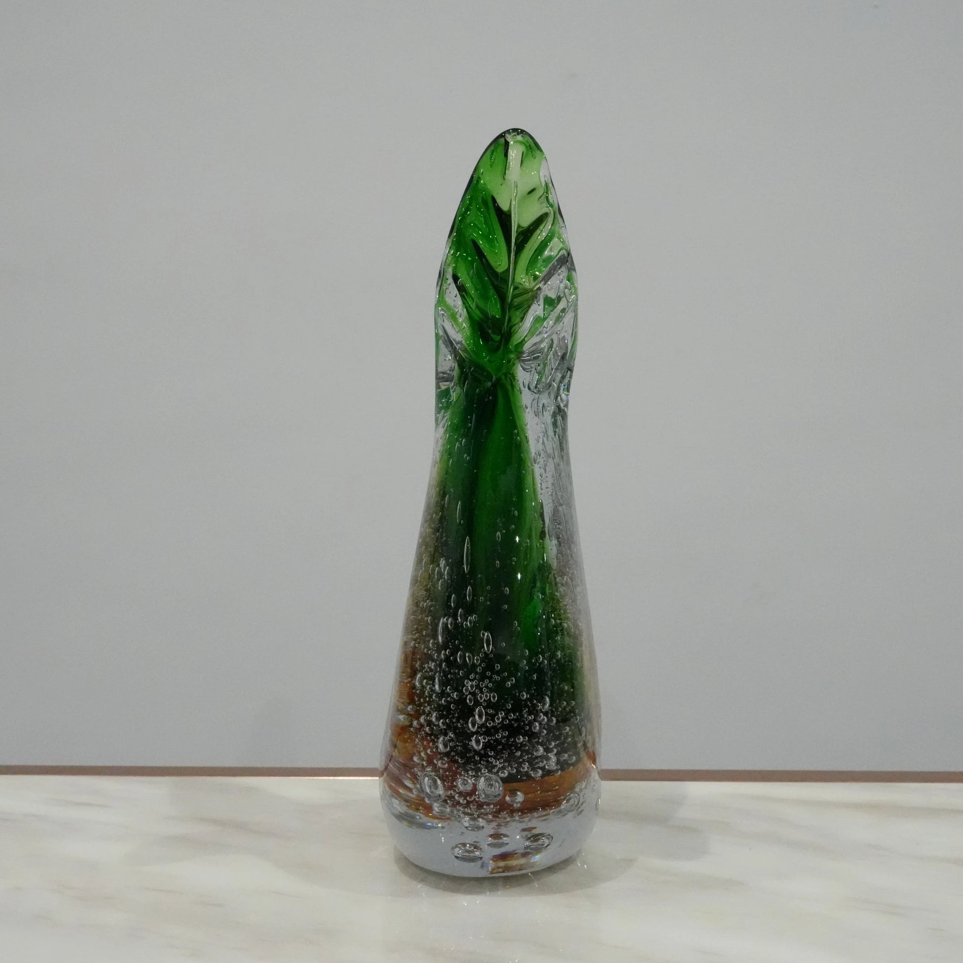 Luxury artisan glass vase with flowing asymmetrical curves and translucent green amber finish for elegant tabletop styling