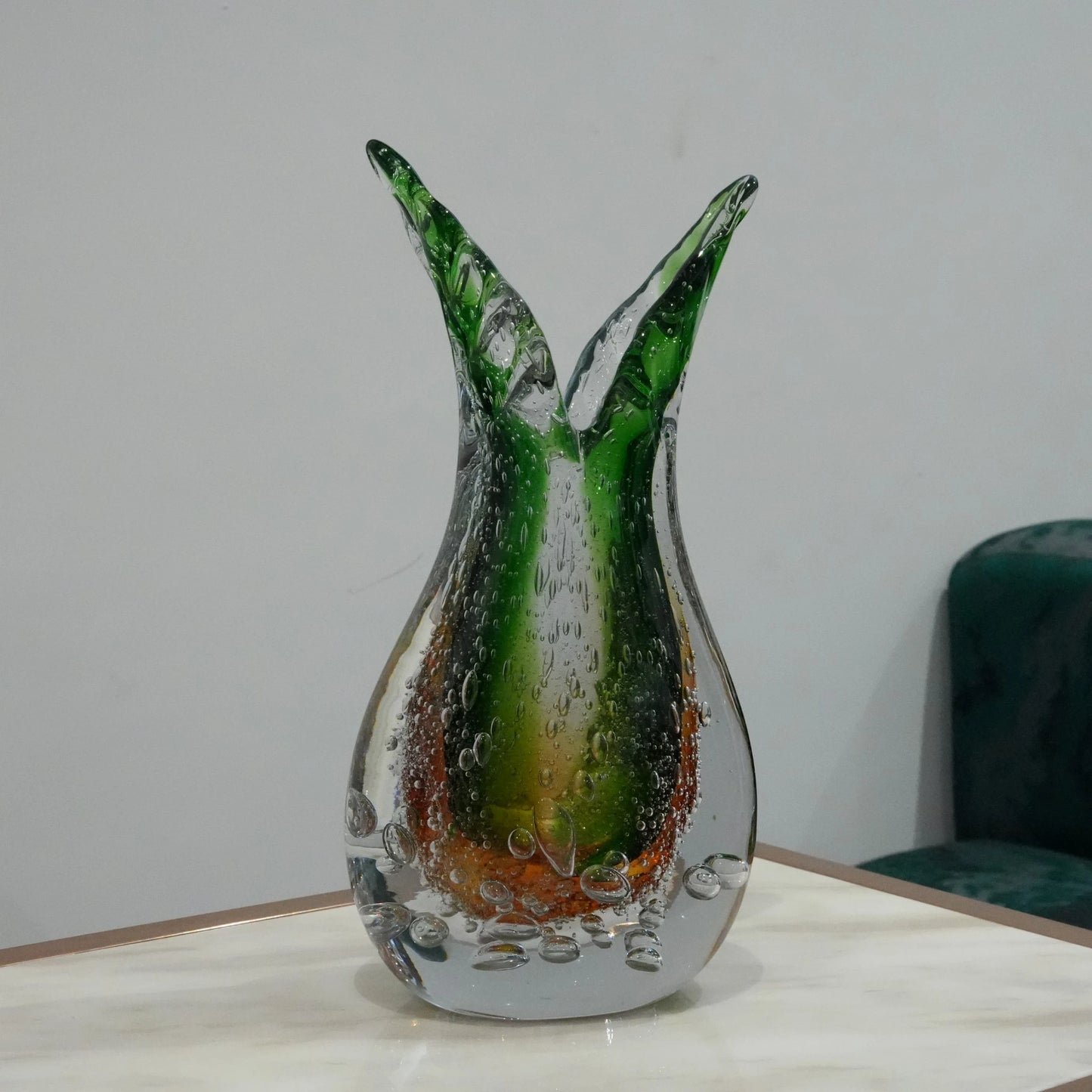 Luxury artisan glass vase with flowing asymmetrical curves and translucent green amber finish for elegant tabletop styling