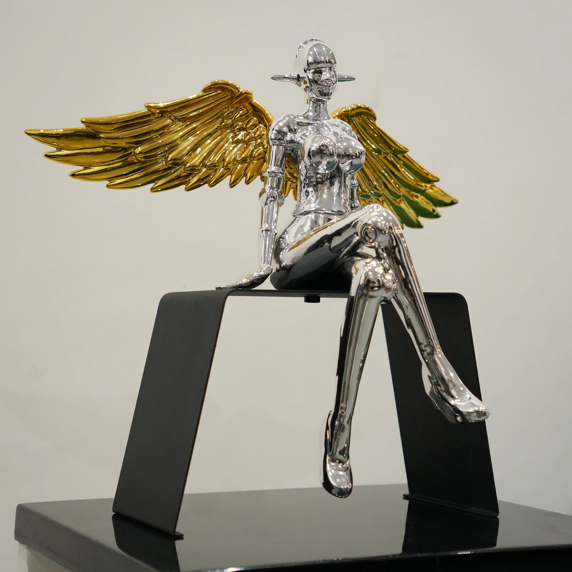Modern silver female decor accent with metallic gold wings and black frame