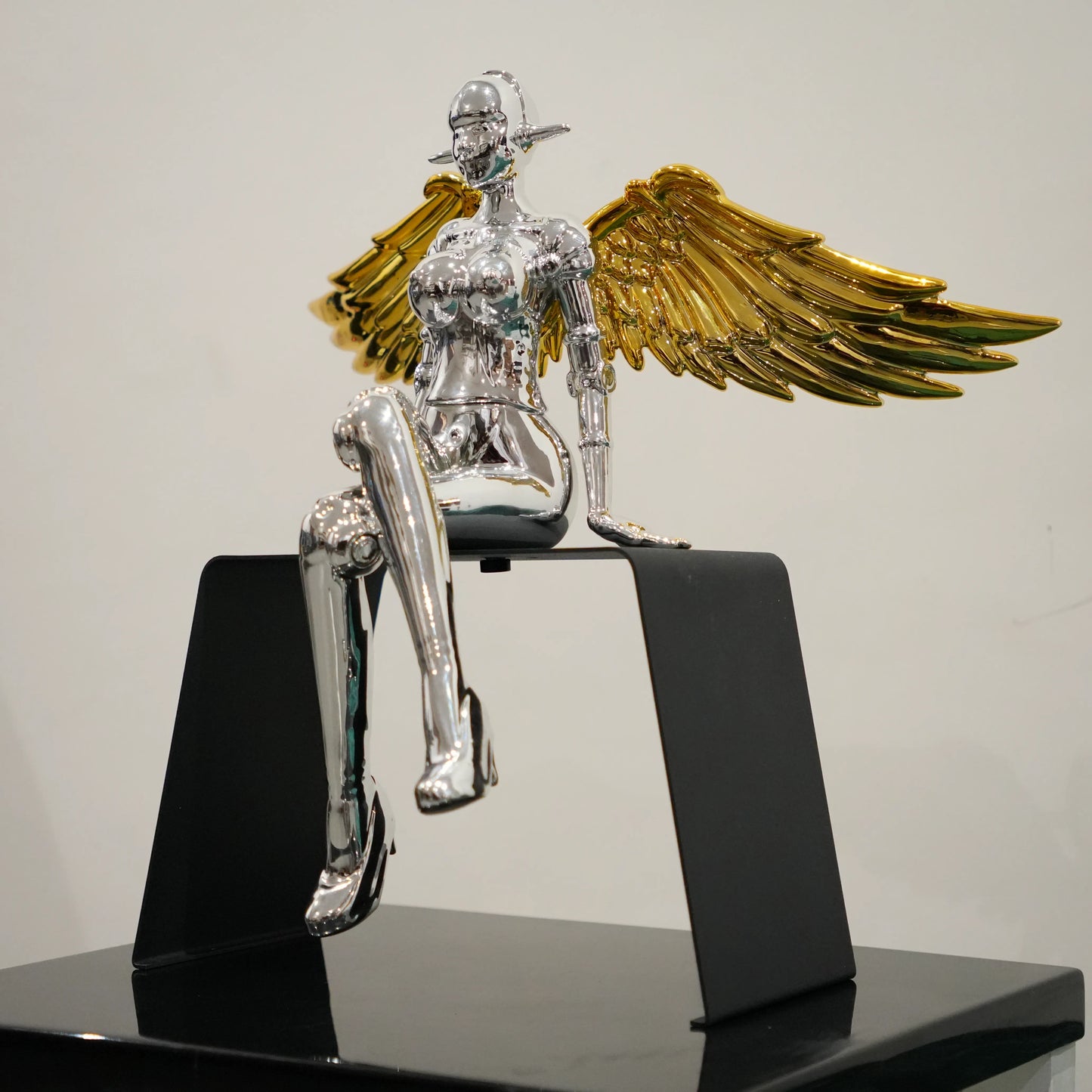 Contemporary silver lady decor featuring gold wings and elevated black frame design