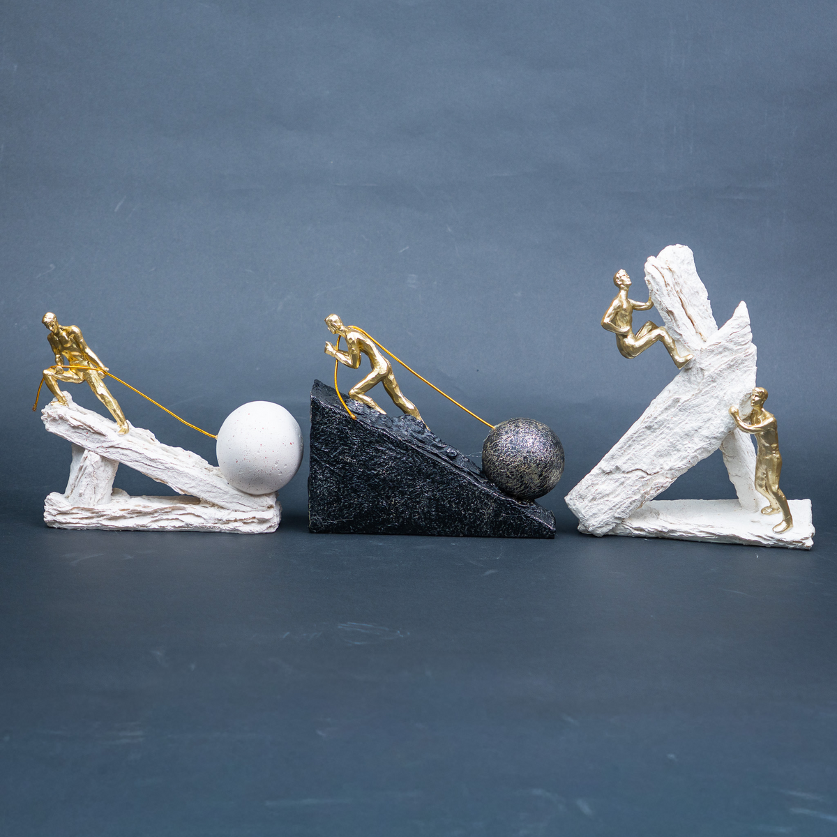 Designer motivational figurine trio with gold human figures and statement bases