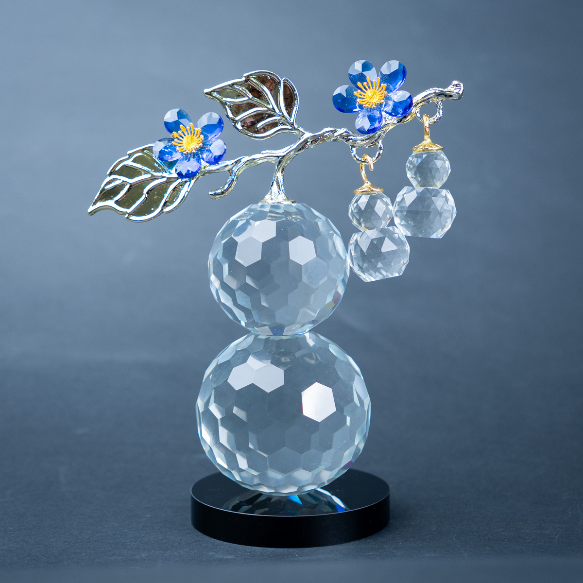 clear crystal decorative piece with floral detailing and metal leaves
