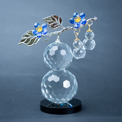 clear crystal decorative piece with floral detailing and metal leaves