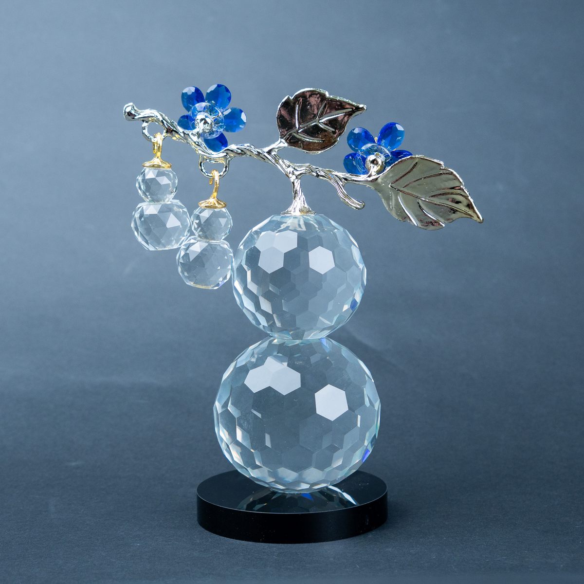 clear crystal decorative piece with floral detailing and metal leaves