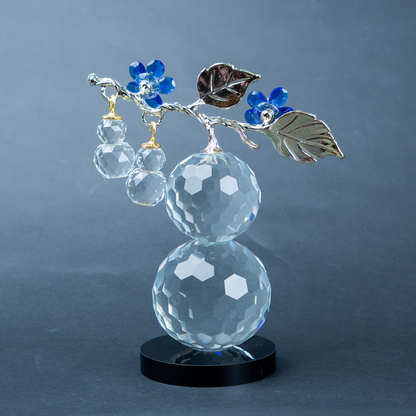 clear crystal decorative piece with floral detailing and metal leaves