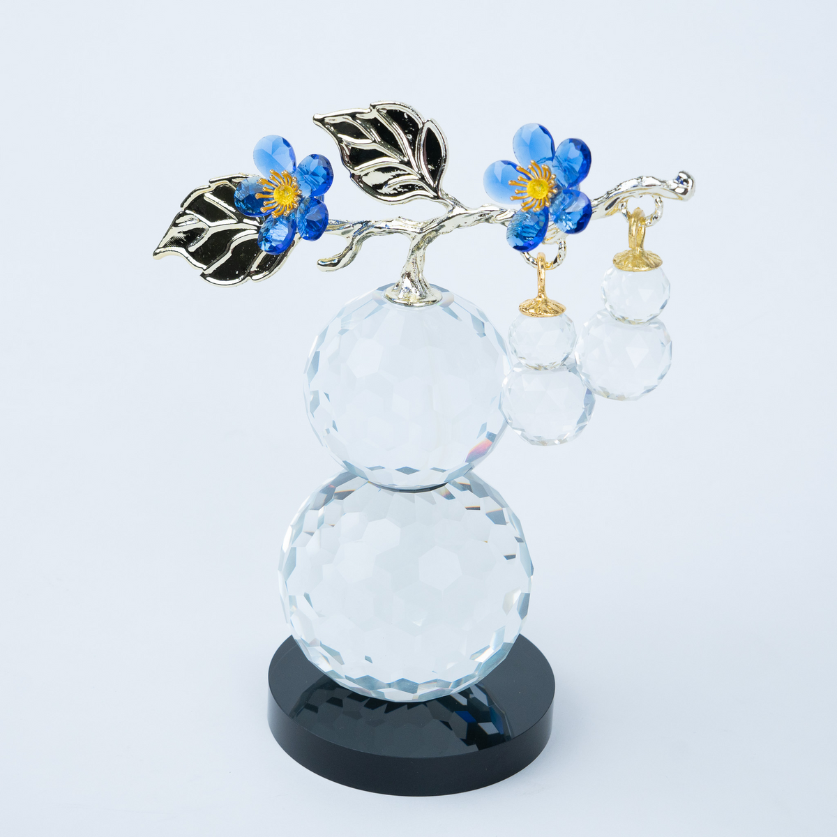 clear crystal decorative piece with floral detailing and metal leaves