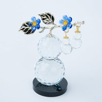 clear crystal decorative piece with floral detailing and metal leaves
