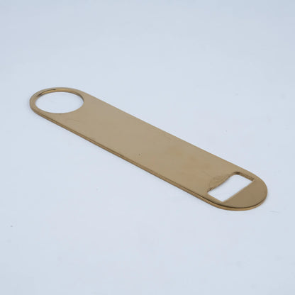 A flat, rectangular bottle opener with rounded corners in a warm gold or brass finish,