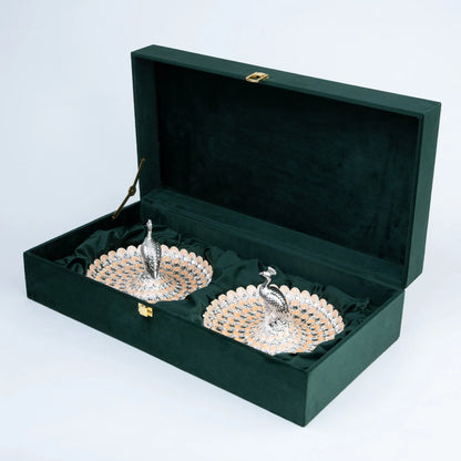 Two ornate peacock platters with layered silver and champagne feather design