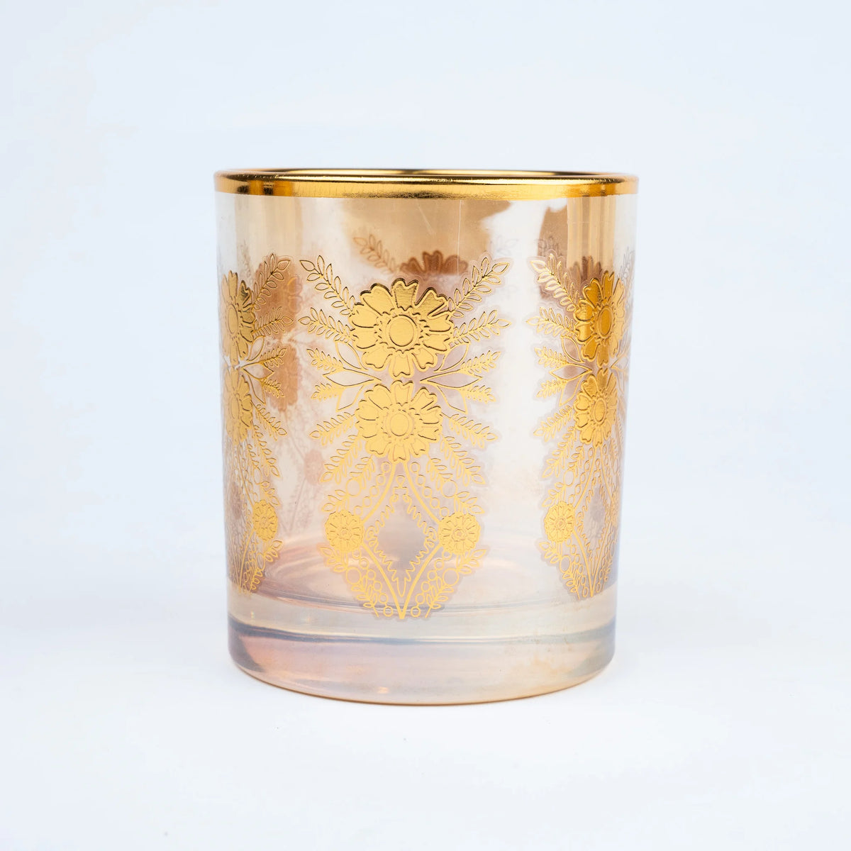 Close-up of luxury drinking glass with intricate gold floral detailing and gold rim