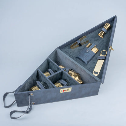 A triangular gray storage case with multiple compartments, shown open on a light gray background. Inside are several metallic gold and gray accessories, including a bottle opener, bottle openers, and small tools.