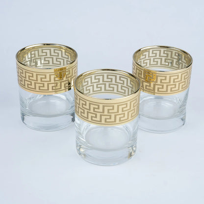 Three clear glass tumblers with gold Greek key pattern bands