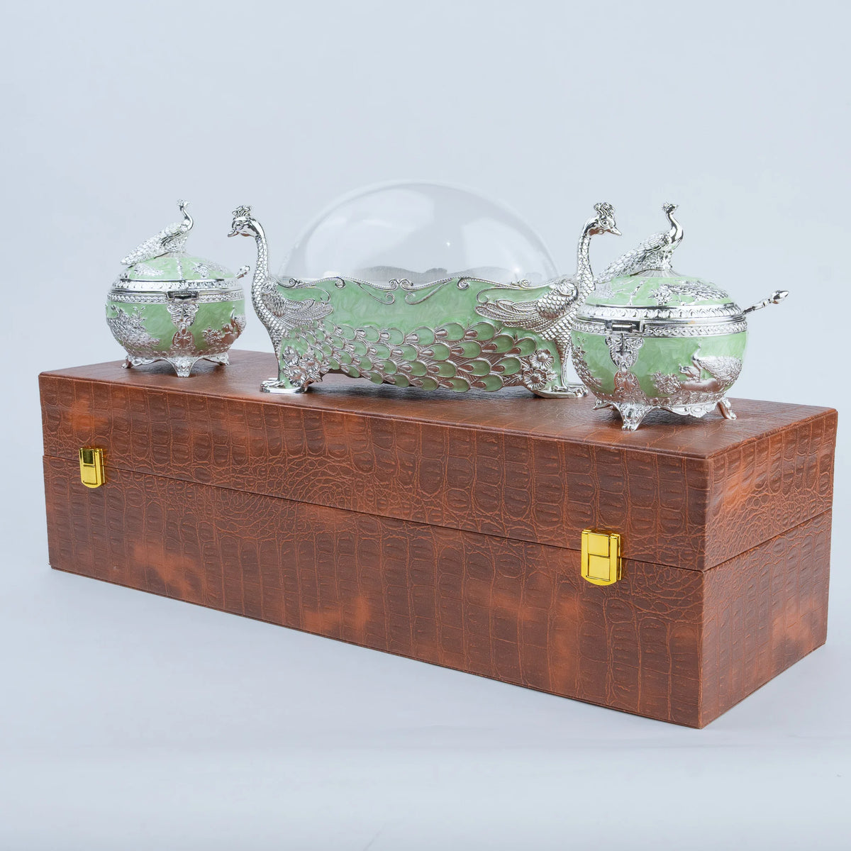 Three-piece green peacock dry fruit box set with silver ornamentation and serving spoons