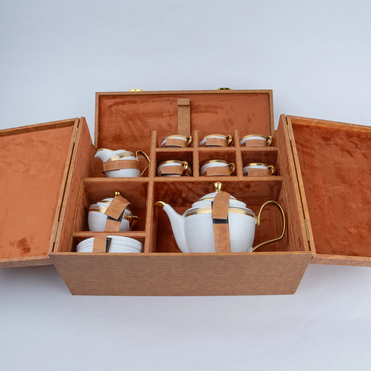 White ceramic tea set with gold accents, six cups and teapot inside textured luxury gift case